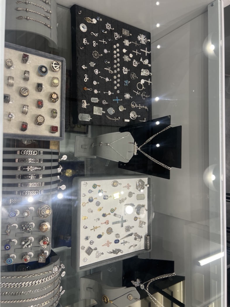 Silver signet rings and a wall of pendants and charms