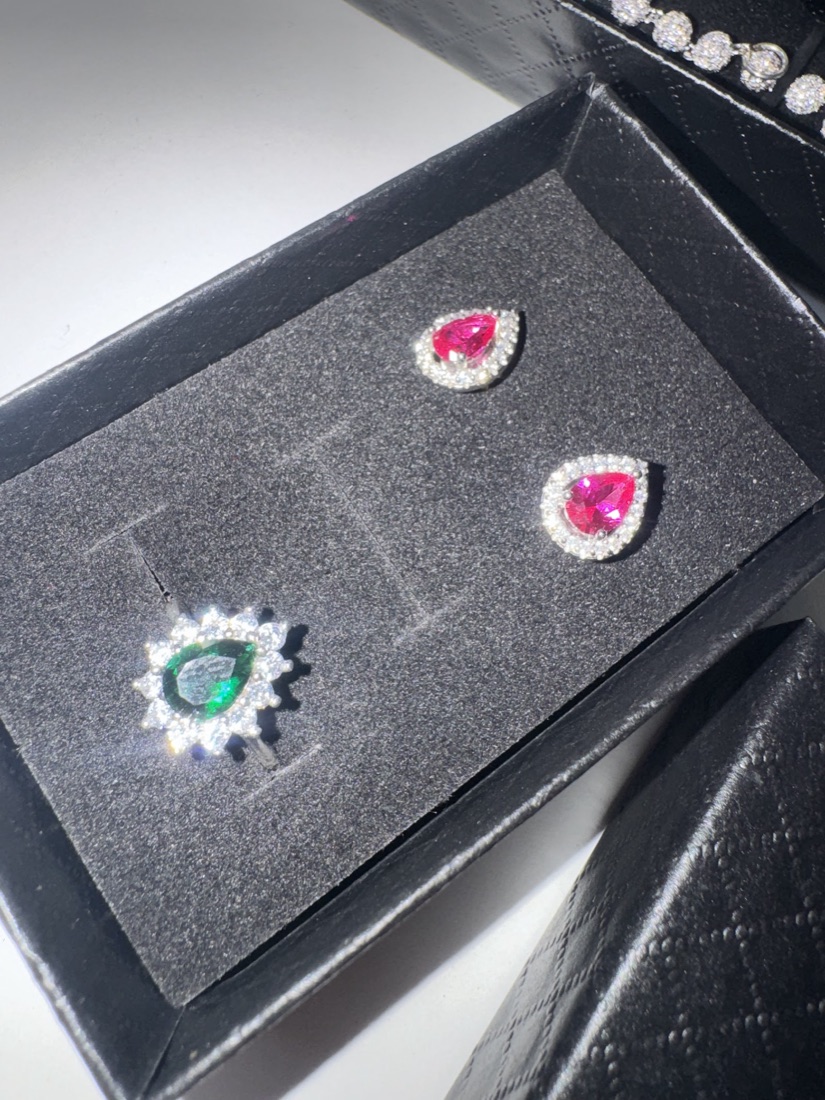 Ruby-red and emerald-green gemstone pieces with a halo of clear stones, boxed at Blue Jewellers, East Ham