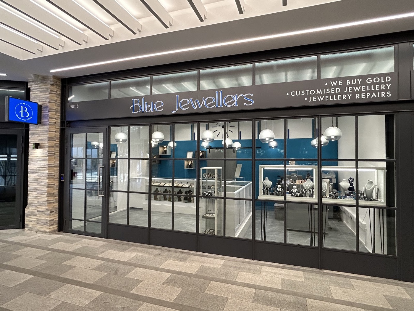 Inside Blue Jewellers with its blue feature wall and lit display cabinets
